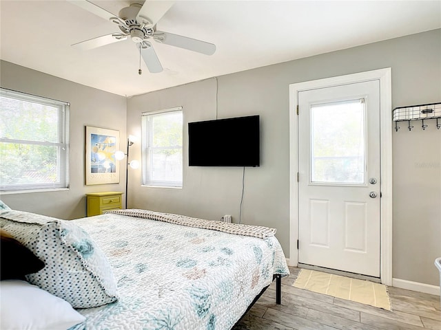 bedroom featuring ceiling fan, baseboards, and light wood-style floors