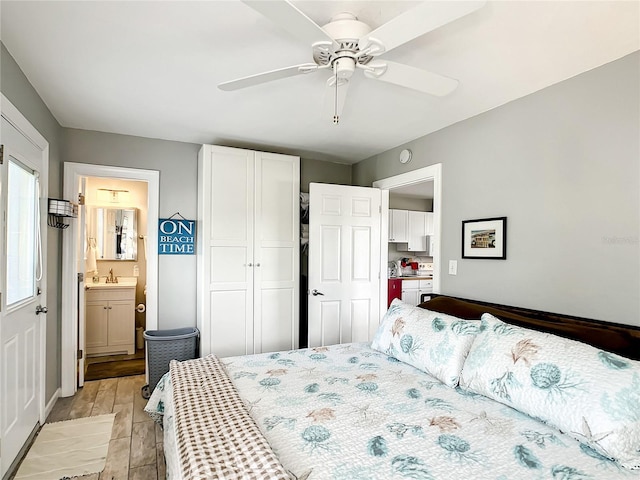 bedroom with a ceiling fan, light wood finished floors, a sink, a closet, and ensuite bathroom