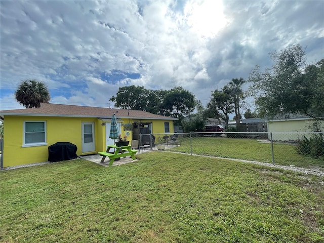 rear view of property featuring a patio area, a lawn, a fenced backyard, and stucco siding