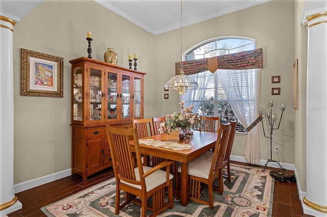 dining room with wood finish floors, crown molding, baseboards, a chandelier, and ornate columns