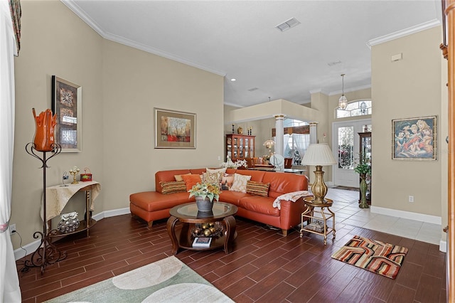 living area featuring wood finish floors, visible vents, baseboards, and crown molding