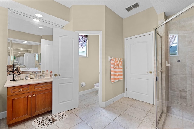 full bath featuring vanity, visible vents, a stall shower, tile patterned floors, and toilet