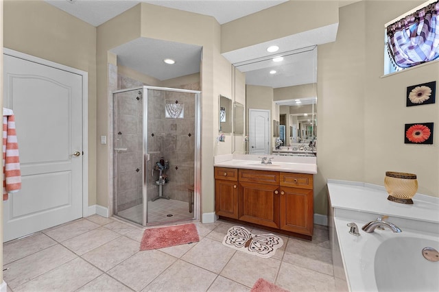 bathroom featuring vanity, baseboards, a shower stall, tile patterned floors, and a washtub