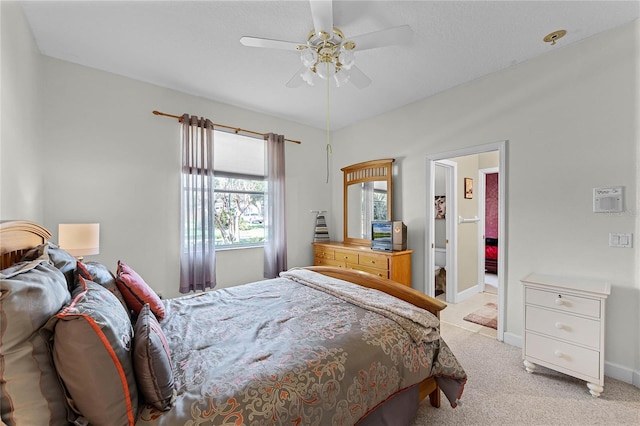 bedroom with a ceiling fan, baseboards, and light carpet