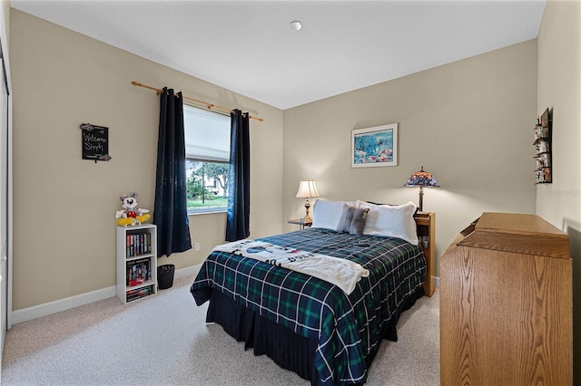 bedroom featuring carpet and baseboards