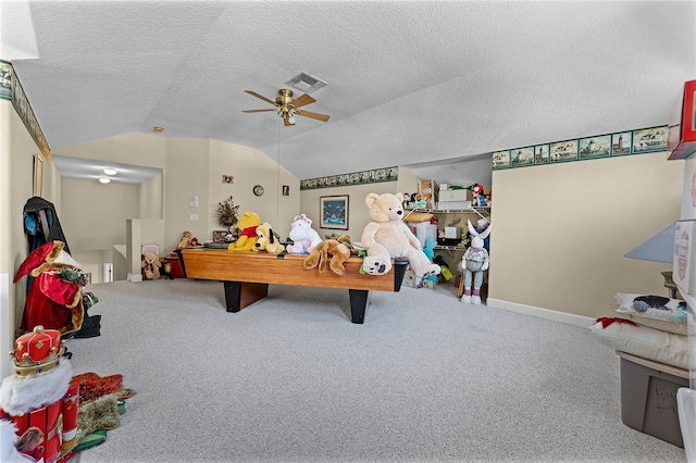 rec room with a ceiling fan, visible vents, vaulted ceiling, a textured ceiling, and carpet flooring