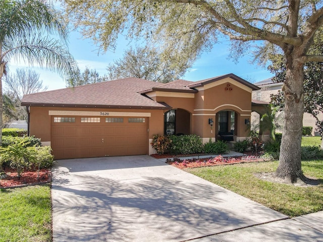 mediterranean / spanish home with a garage, concrete driveway, and stucco siding