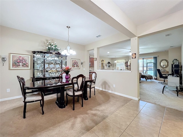 dining room with light carpet, visible vents, baseboards, and light tile patterned floors