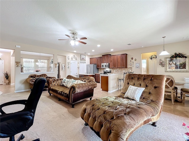 living room with light carpet, ceiling fan, light tile patterned flooring, a textured ceiling, and recessed lighting