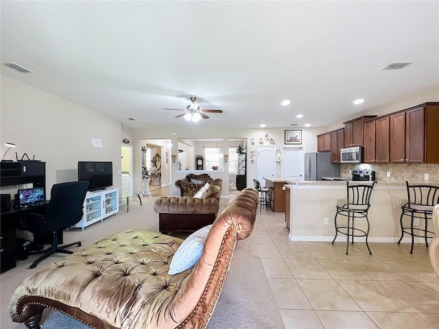 living area with recessed lighting, ceiling fan, visible vents, and light tile patterned flooring