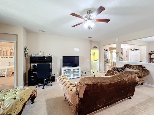 living area with visible vents, a ceiling fan, and light colored carpet