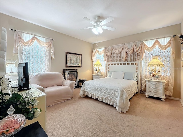 bedroom featuring ceiling fan, multiple windows, and carpet