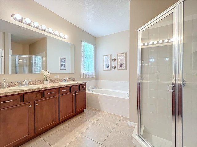 full bathroom with a bath, a stall shower, a sink, and tile patterned floors