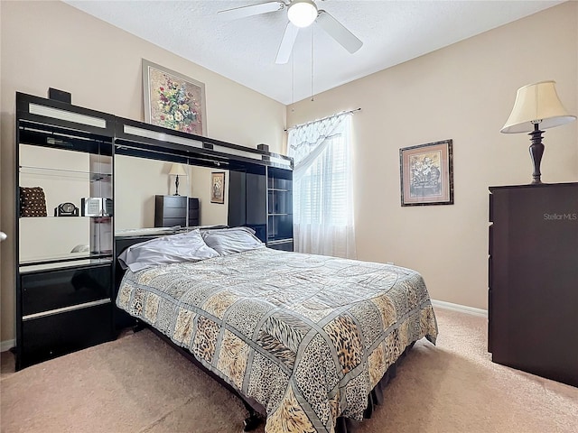 bedroom with a textured ceiling, carpet flooring, a ceiling fan, and baseboards