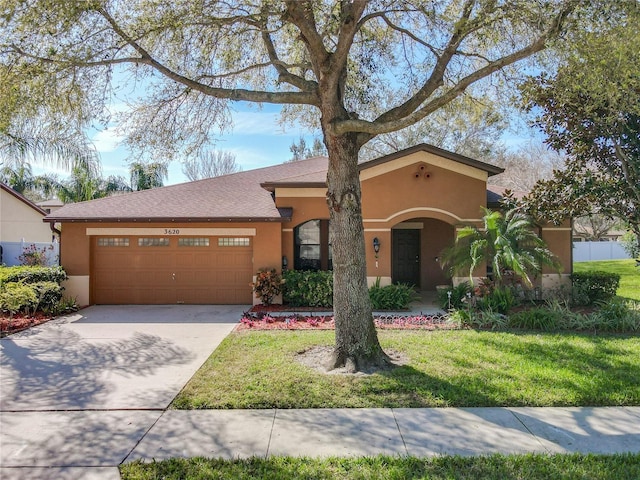 view of front of home featuring driveway, a front yard, a garage, and stucco siding