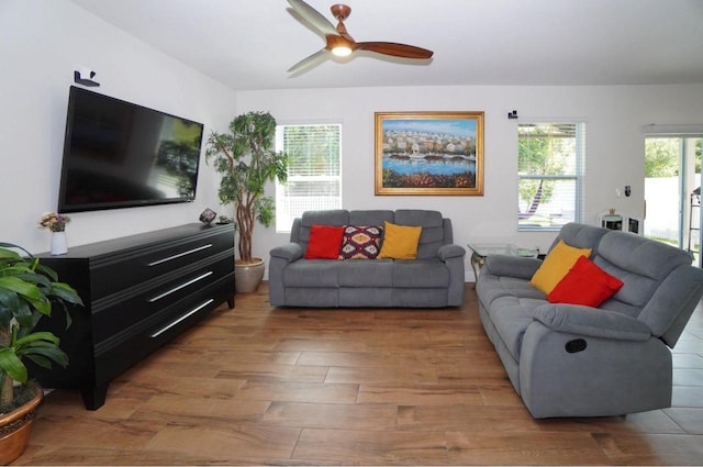 living area with a ceiling fan and wood finished floors