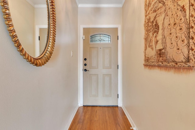 doorway to outside featuring baseboards, wood finished floors, and ornamental molding