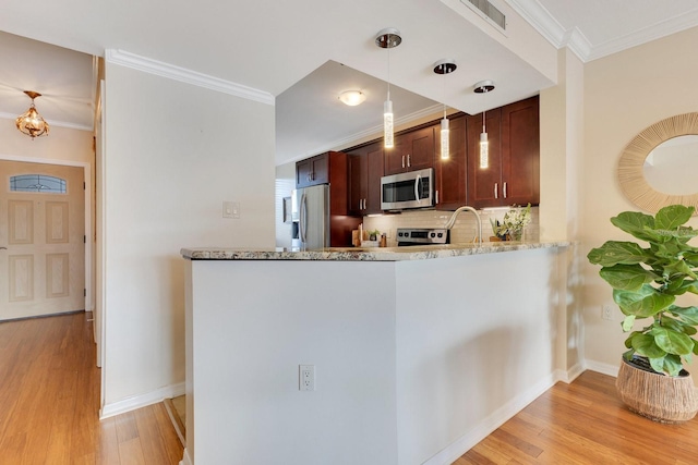 kitchen featuring light stone countertops, appliances with stainless steel finishes, ornamental molding, and light wood finished floors