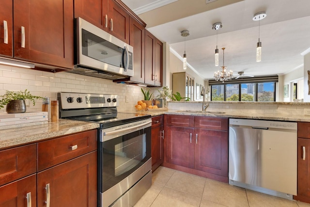 kitchen with a sink, stainless steel appliances, crown molding, tasteful backsplash, and reddish brown cabinets