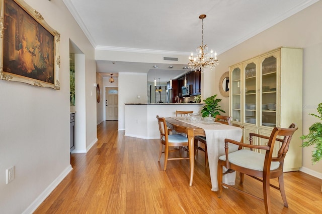 dining room featuring crown molding, visible vents, baseboards, and light wood finished floors