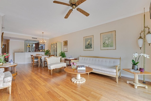 living area with light wood-style flooring, ceiling fan with notable chandelier, crown molding, and baseboards