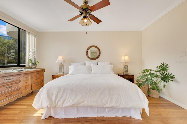 bedroom featuring crown molding, baseboards, light wood finished floors, and ceiling fan