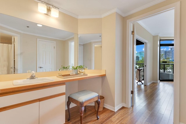 full bathroom featuring vanity, crown molding, baseboards, and wood finished floors