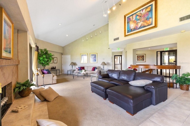 living area with visible vents, high vaulted ceiling, a fireplace with raised hearth, and light colored carpet