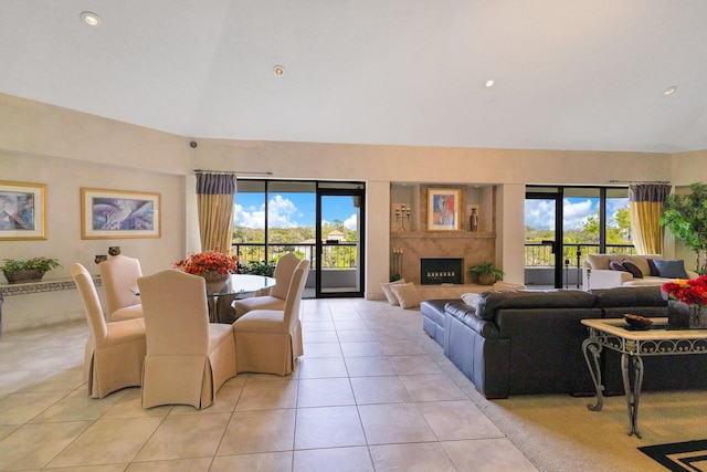 living area featuring a wealth of natural light, lofted ceiling, light tile patterned flooring, and a fireplace