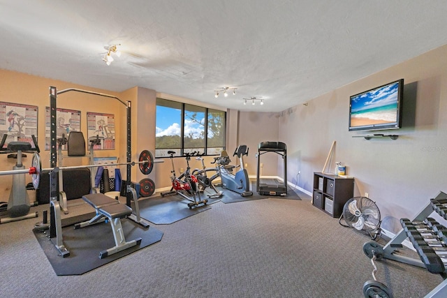 exercise room featuring baseboards and a textured ceiling