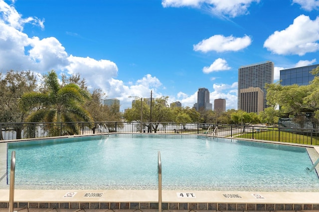 pool with a city view and fence