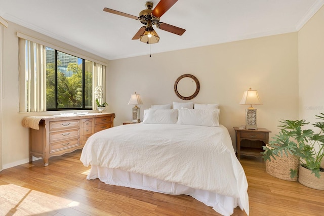 bedroom featuring baseboards, light wood-type flooring, and ornamental molding