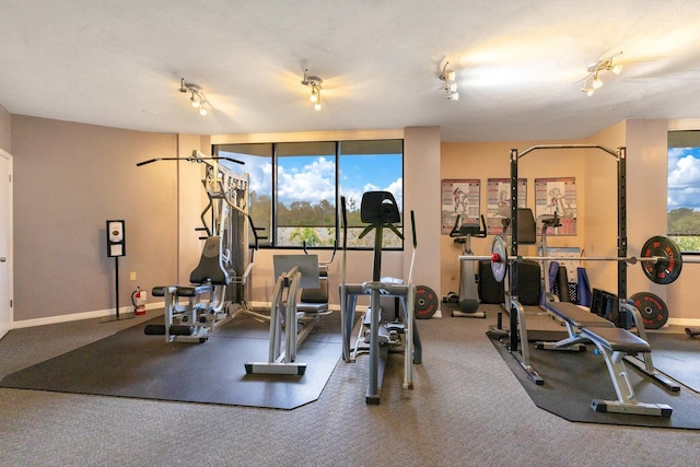 gym featuring rail lighting and baseboards