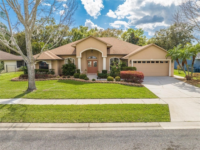 view of front of property featuring stucco siding, driveway, a shingled roof, an attached garage, and a front yard