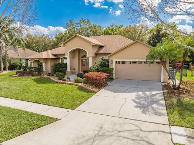 ranch-style house with a front yard, an attached garage, concrete driveway, and stucco siding