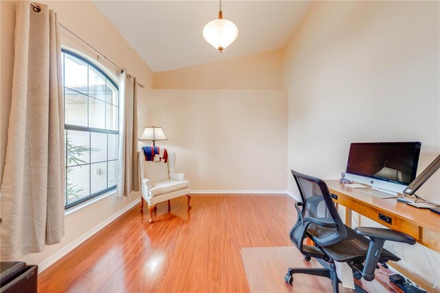 office featuring a wealth of natural light, wood finished floors, baseboards, and vaulted ceiling