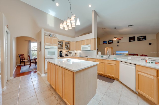 kitchen featuring visible vents, light brown cabinets, white appliances, arched walkways, and light tile patterned floors