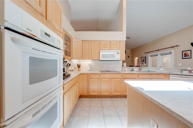 kitchen featuring a sink, white appliances, light brown cabinets, and light tile patterned floors