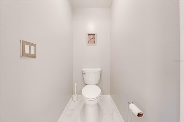 bathroom with toilet and baseboards