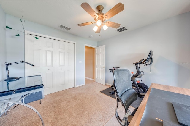 carpeted office with visible vents, baseboards, and a ceiling fan