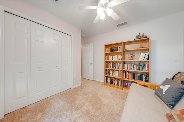 living area featuring visible vents, a ceiling fan, and carpet floors