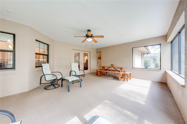 living area with french doors, carpet floors, and ceiling fan