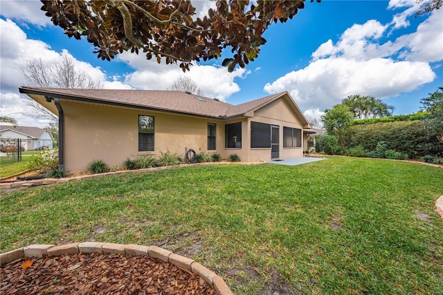 back of property featuring stucco siding and a lawn