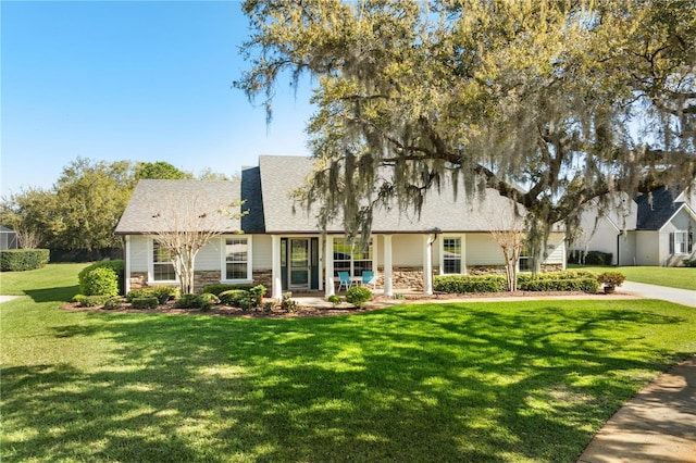 view of front of house with a front yard and stone siding