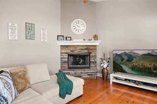 living area featuring a stone fireplace and hardwood / wood-style flooring