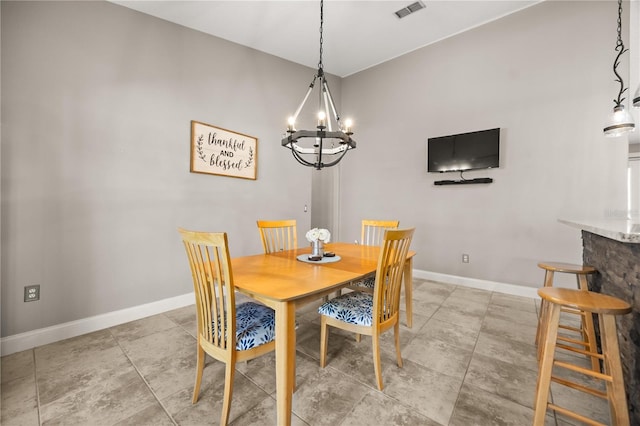 dining room with a notable chandelier, visible vents, and baseboards