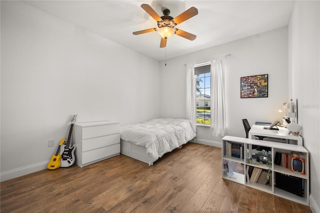 bedroom featuring a ceiling fan, baseboards, and hardwood / wood-style floors