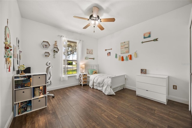 bedroom featuring a ceiling fan, baseboards, and wood finished floors