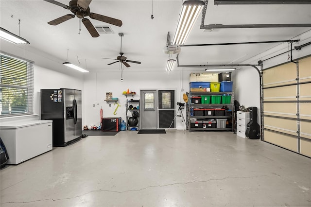 garage with fridge, stainless steel fridge, and visible vents