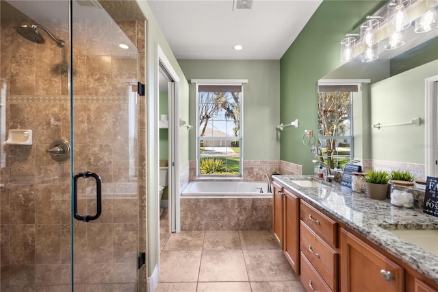 full bathroom with a garden tub, double vanity, toilet, a stall shower, and a sink